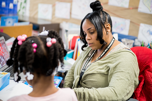 Teacher with student reading a book